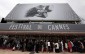 Visitors wait to enter in the Festival Palace covered by a giant canvas of the official poster of the 66th Cannes Film Festival in Cannes May 15, 2013. The 66th Cannes Film Festival will run from May 15 to May 26.     REUTERS/Eric Gaillard (FRANCE  - Tags: ENTERTAINMENT)